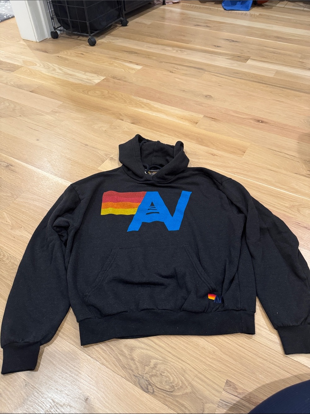 Aviator Nation Black Hoodie with Blue 'A' and Red-Orange-Yellow Stripe